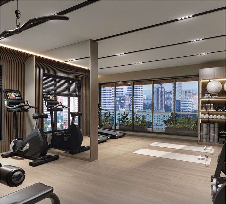 Gym fitted with cycles and treadmills beside a glazed wall looking out over the city.