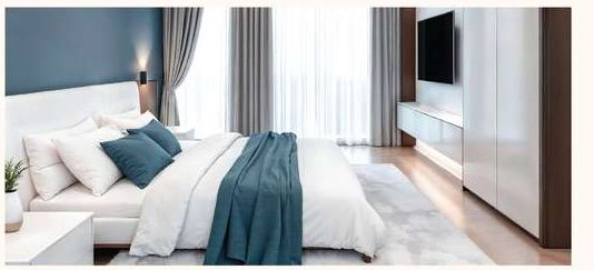Bedroom with a double bed, full-height curtains and fitted storage along one wall.